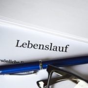 Lebenslauf mit Kugelschreiber und Brille