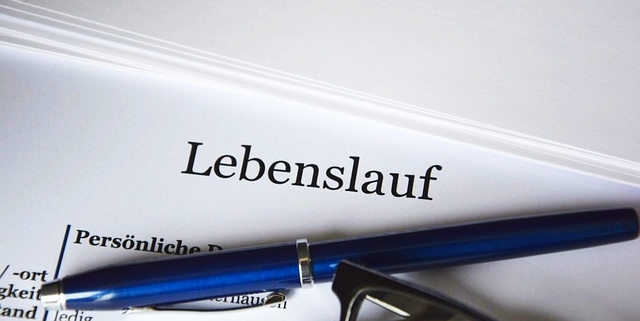 Lebenslauf mit Kugelschreiber und Brille