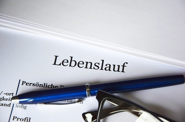 Lebenslauf mit Kugelschreiber und Brille