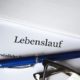 Lebenslauf mit Kugelschreiber und Brille